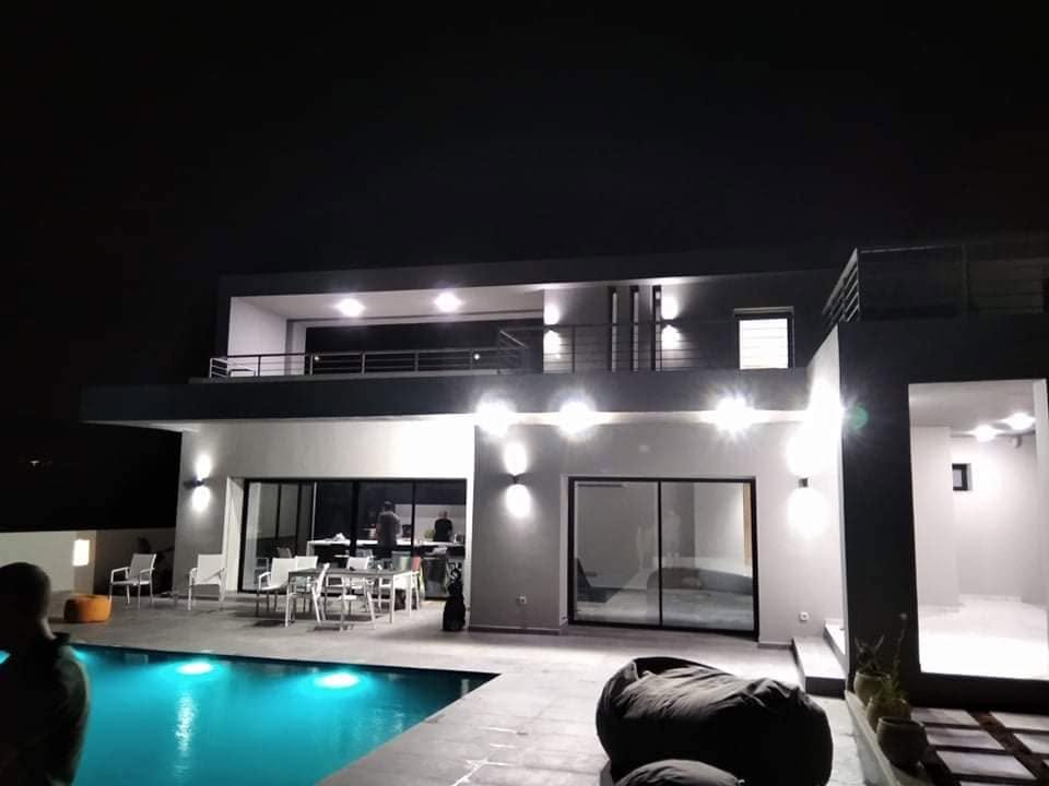 Villa avec piscine illuminée la nuit, chantier Adamas Travaux